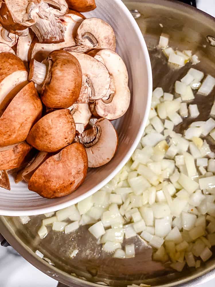 process shot showing adding mushrooms to pan