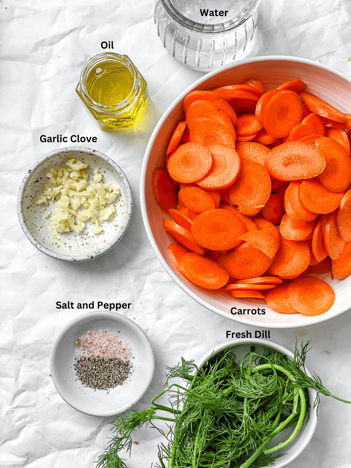 ingredients for Simple Sautéed Carrots measured out on a white surface