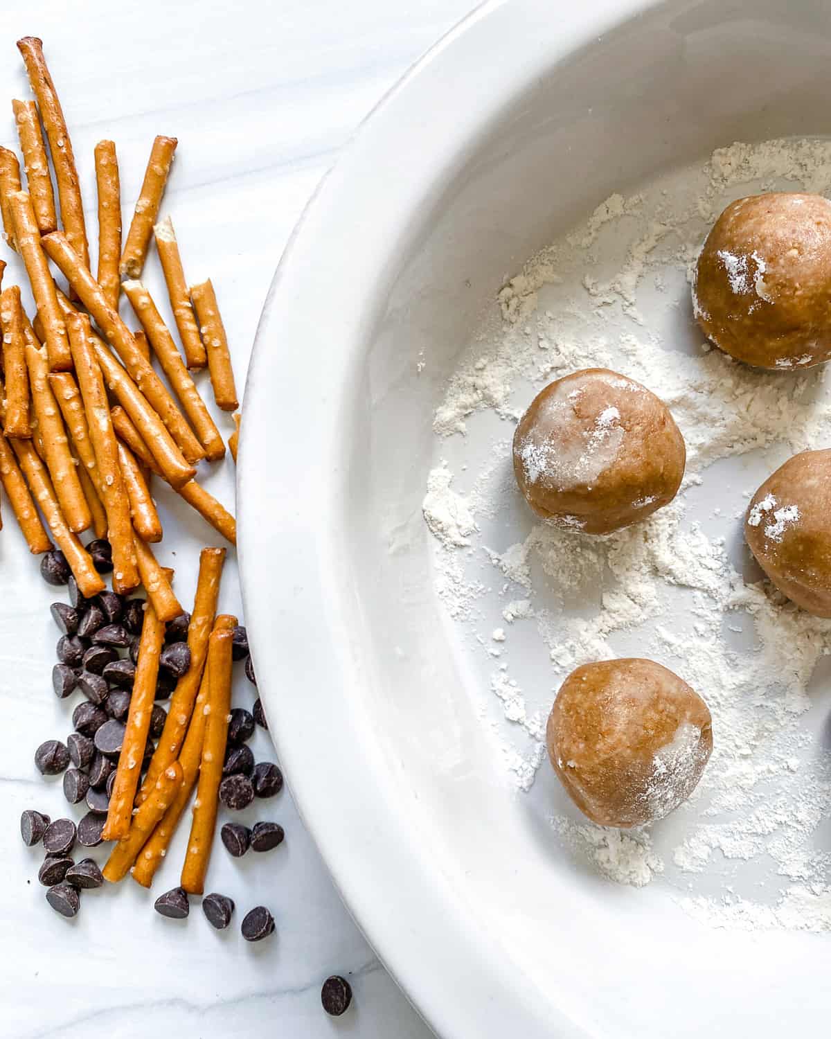 process shot showing peanut butter balls alongside pretzels and vegan chocolate chips