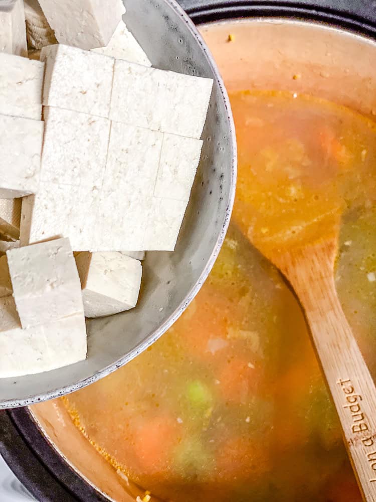 process shot showing tofu being added to pot