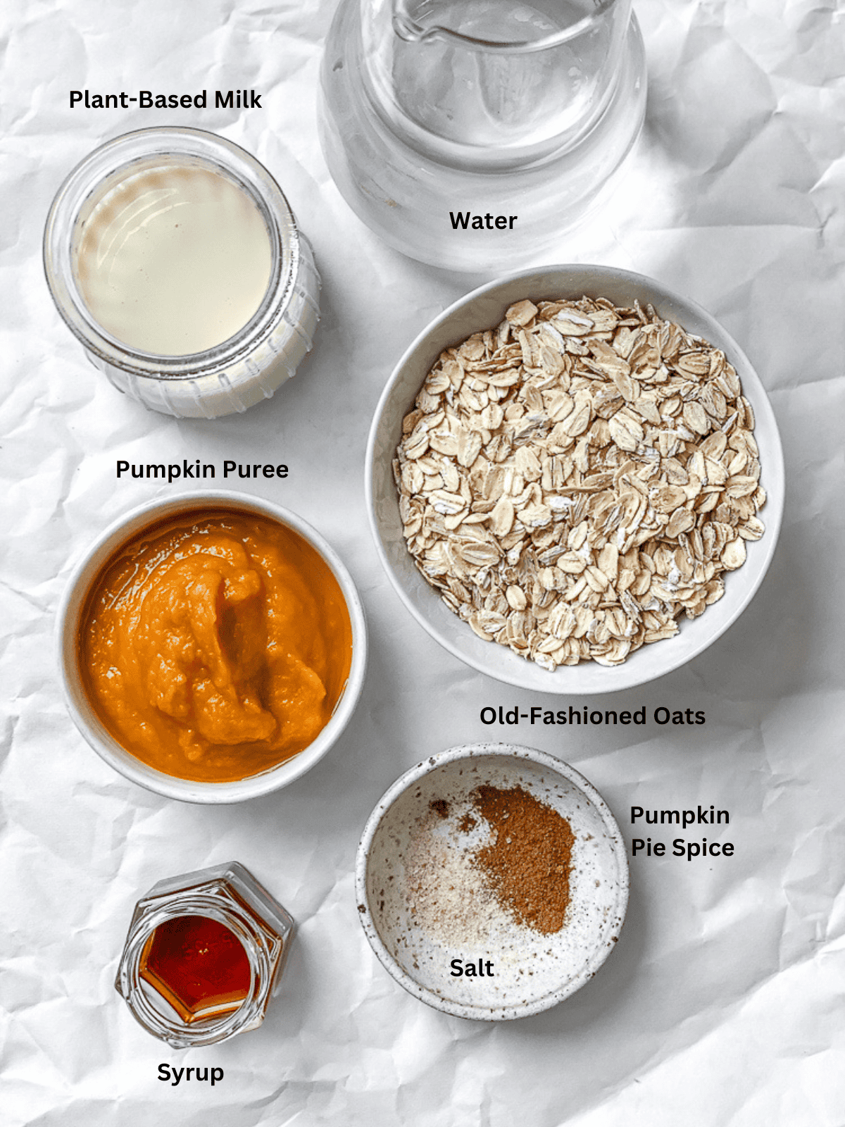 ingredients for Easy Pumpkin Oatmeal measured out on a white surface