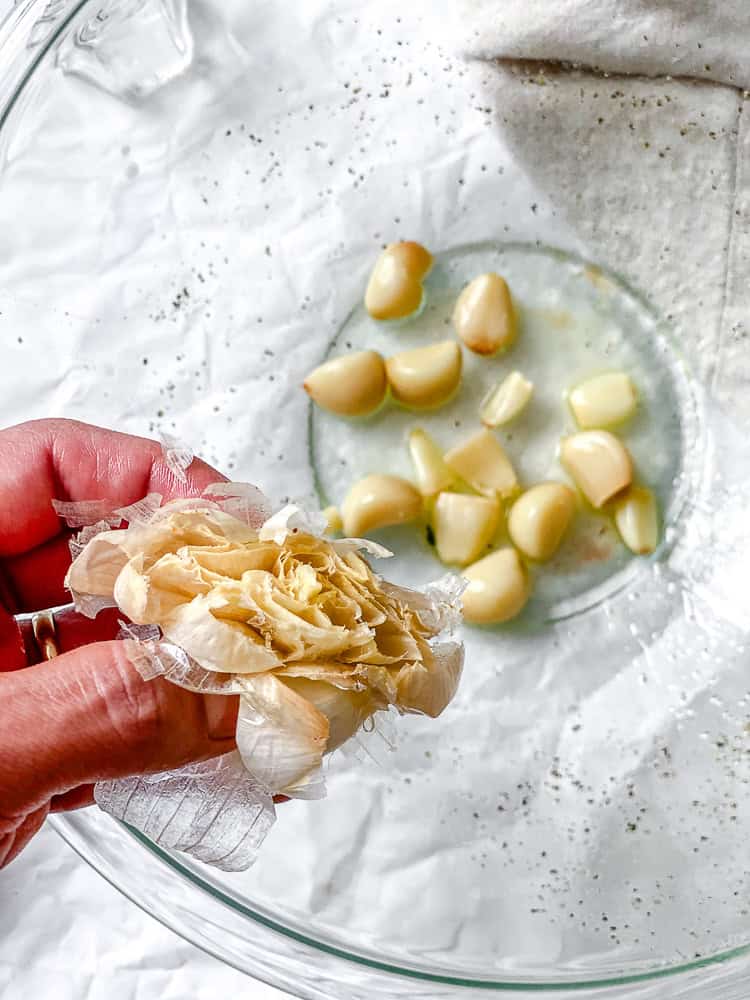 process shot of squeezing garlic into a bowl