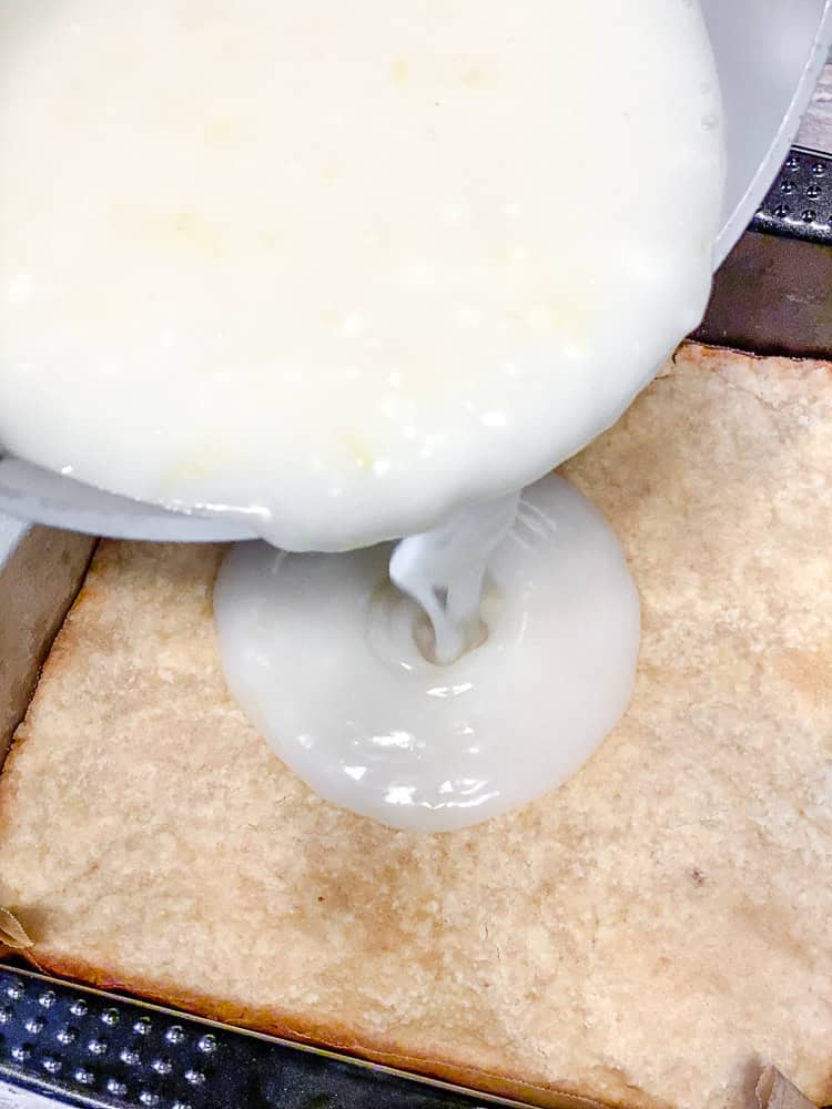 process shot of adding lemon filling to baking dish