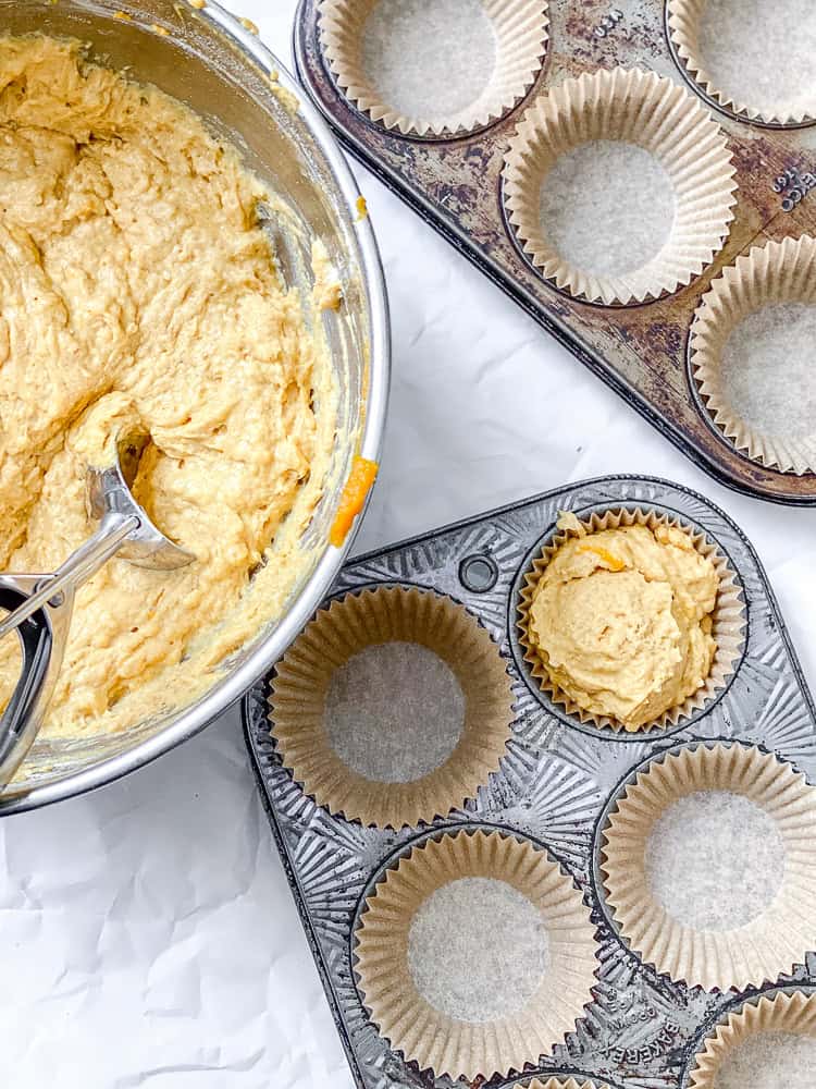 process shot showing adding batter to muffin tin