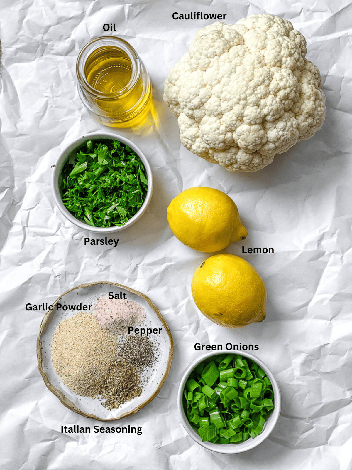 ingredients for Roasted Cauliflower with Lemon and Herbs measured out on a white surface