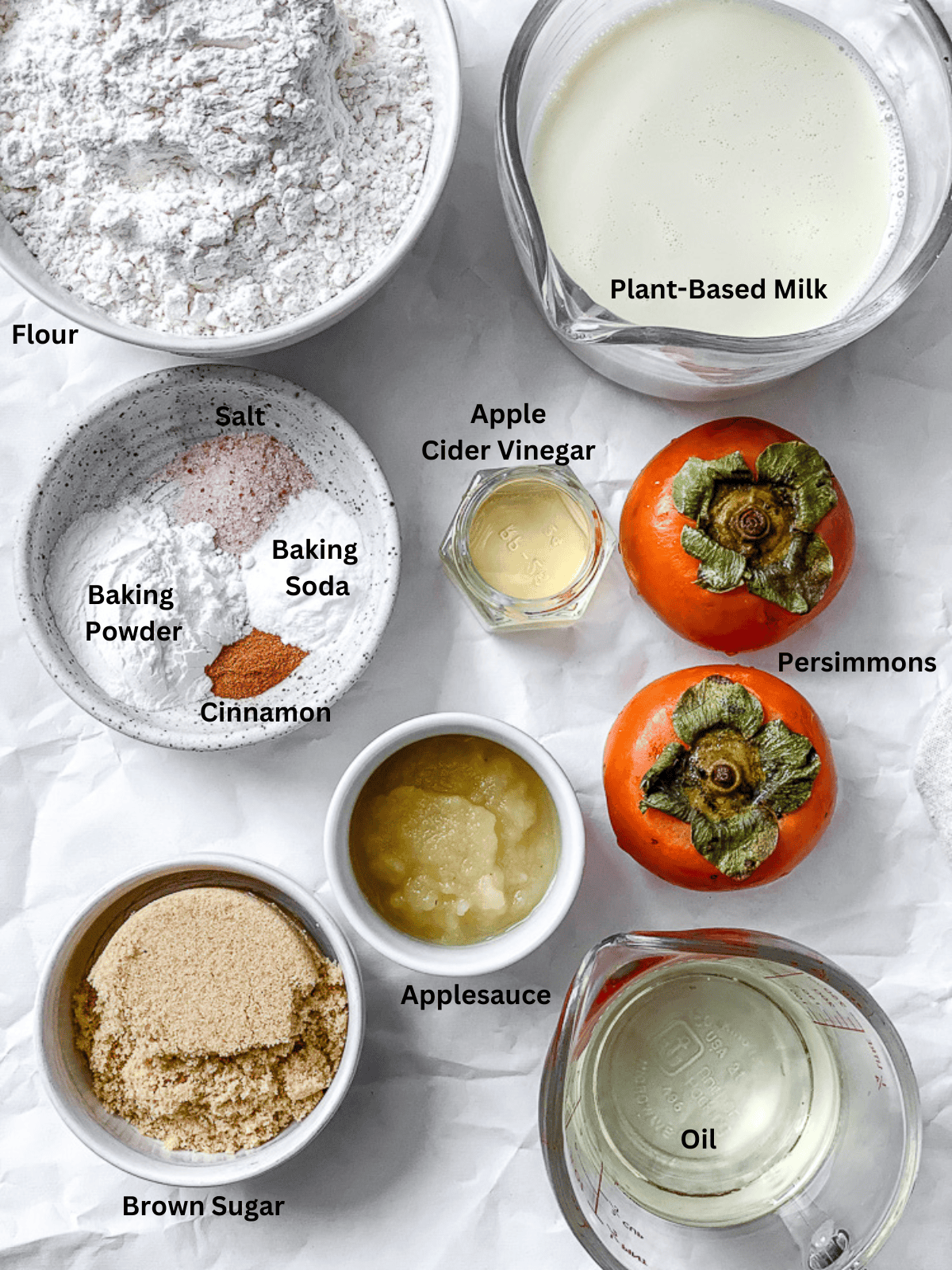 ingredients for Easy Persimmon Muffins measured out on a white surface