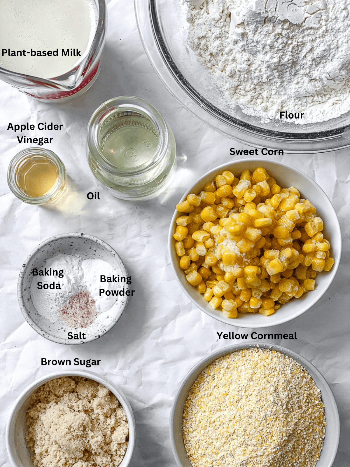 ingredients for Vegan Cornbread Muffins measured out on a white surface