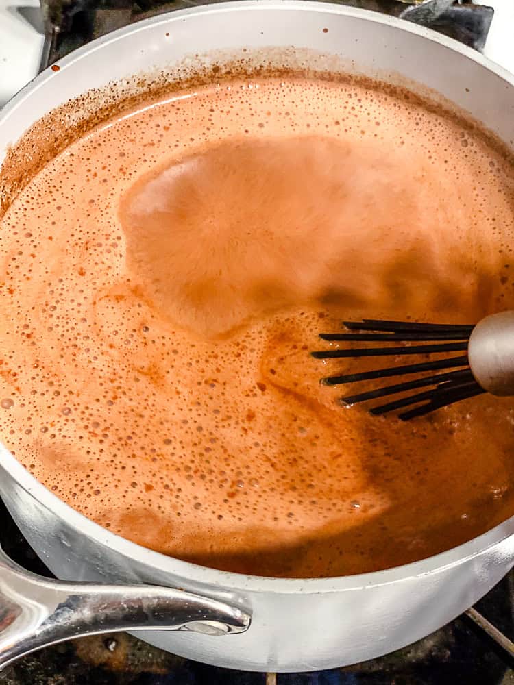 process shot showing stirring ingredients in pot with whisk