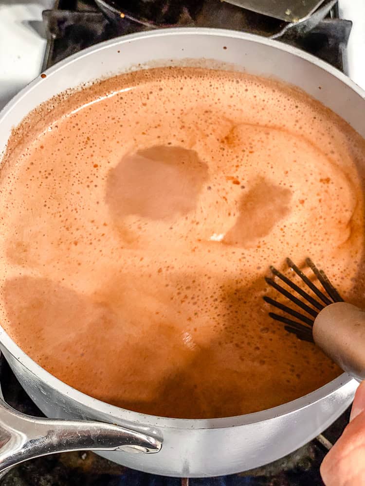 Thick, creamy vegan hot chocolate being whisked in a saucepan