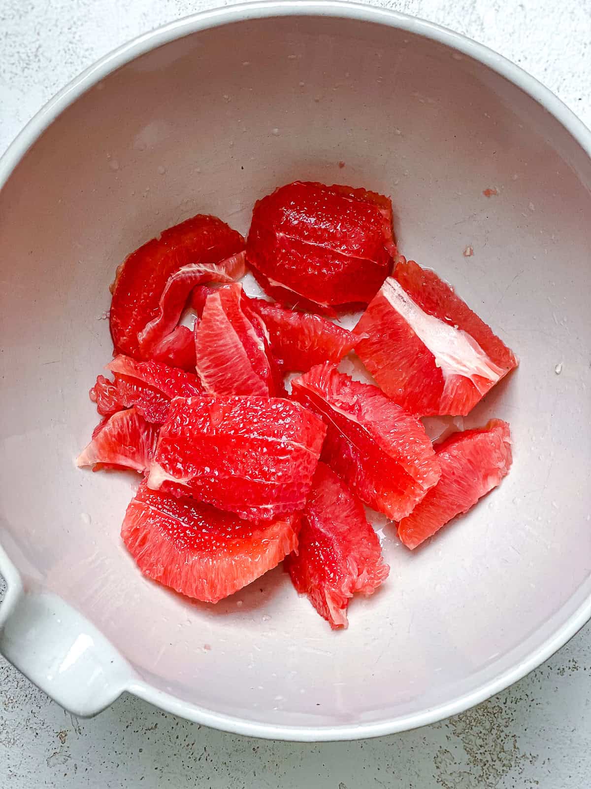 Process shot showing grapefruit in bowl.