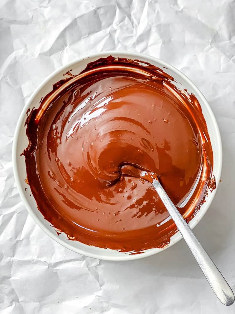 Process shot showing mixing vegan chocolate in bowl.