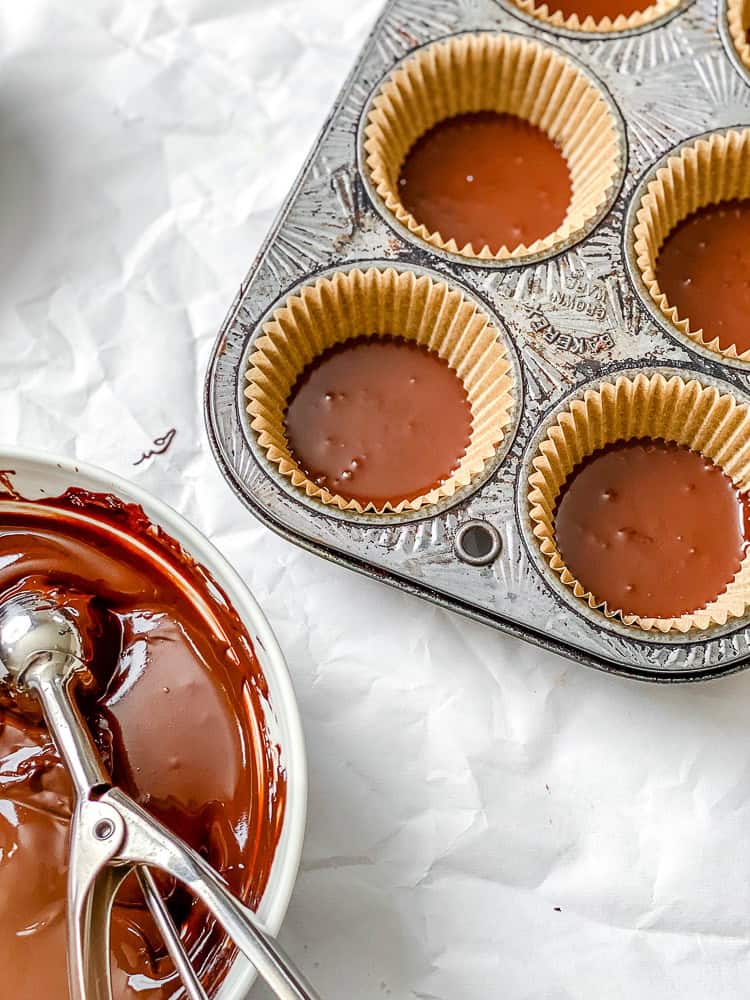 Process shot showing vegan chocolate added to muffin tin.