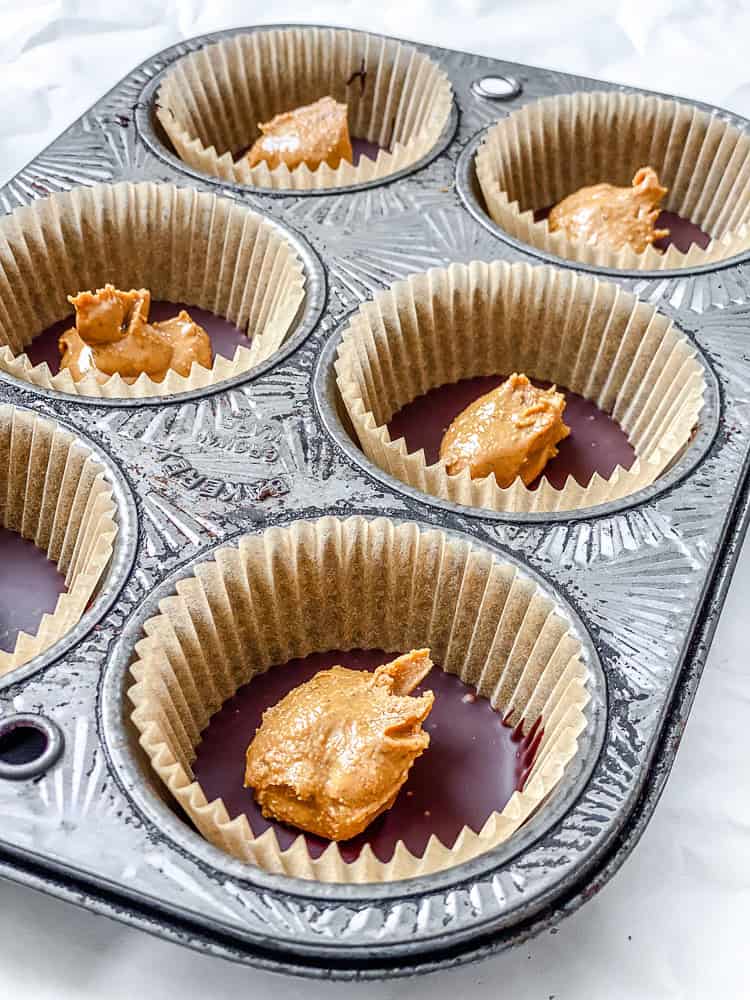 Process shot showing peanut butter added to muffin tin.