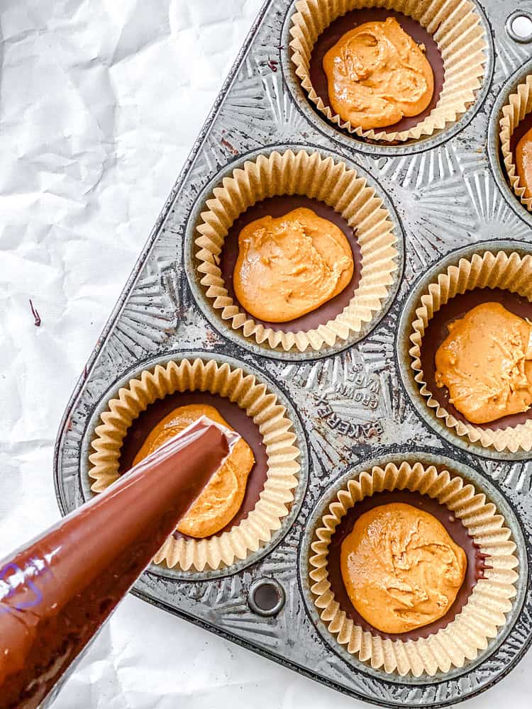 Process shot showing adding vegan chocolate to muffin tin.