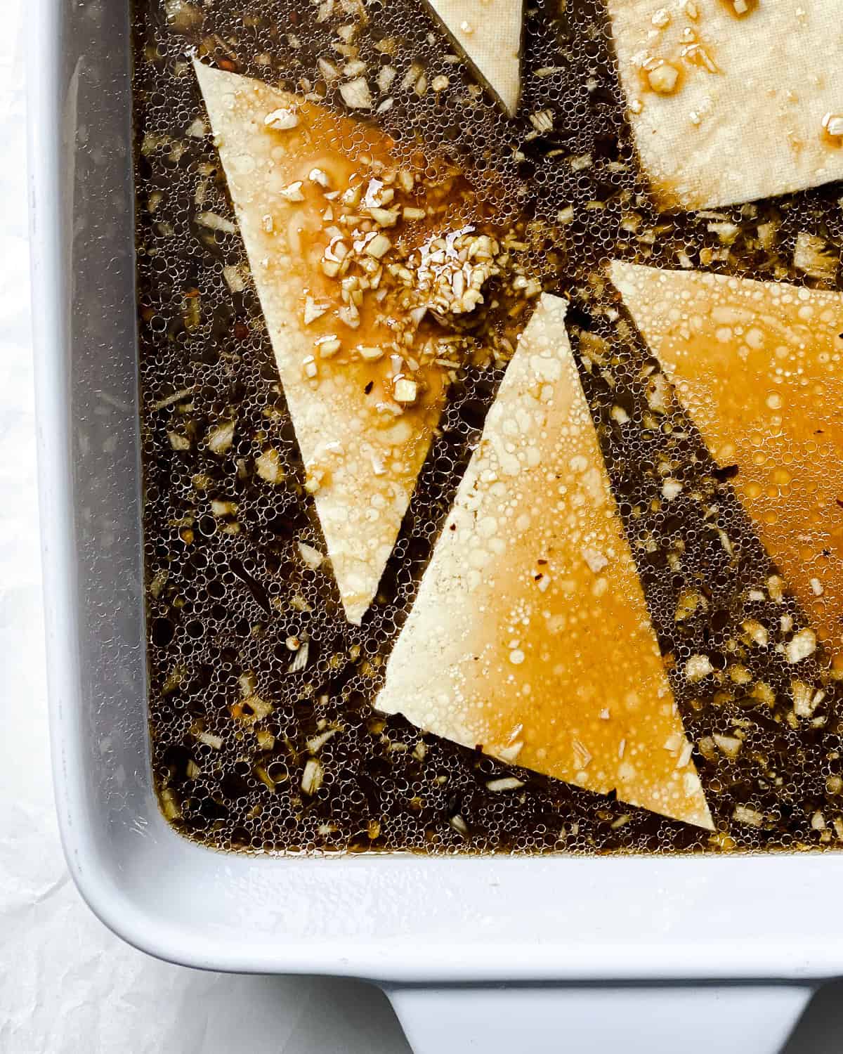 process shot showing tofu slices in marinade