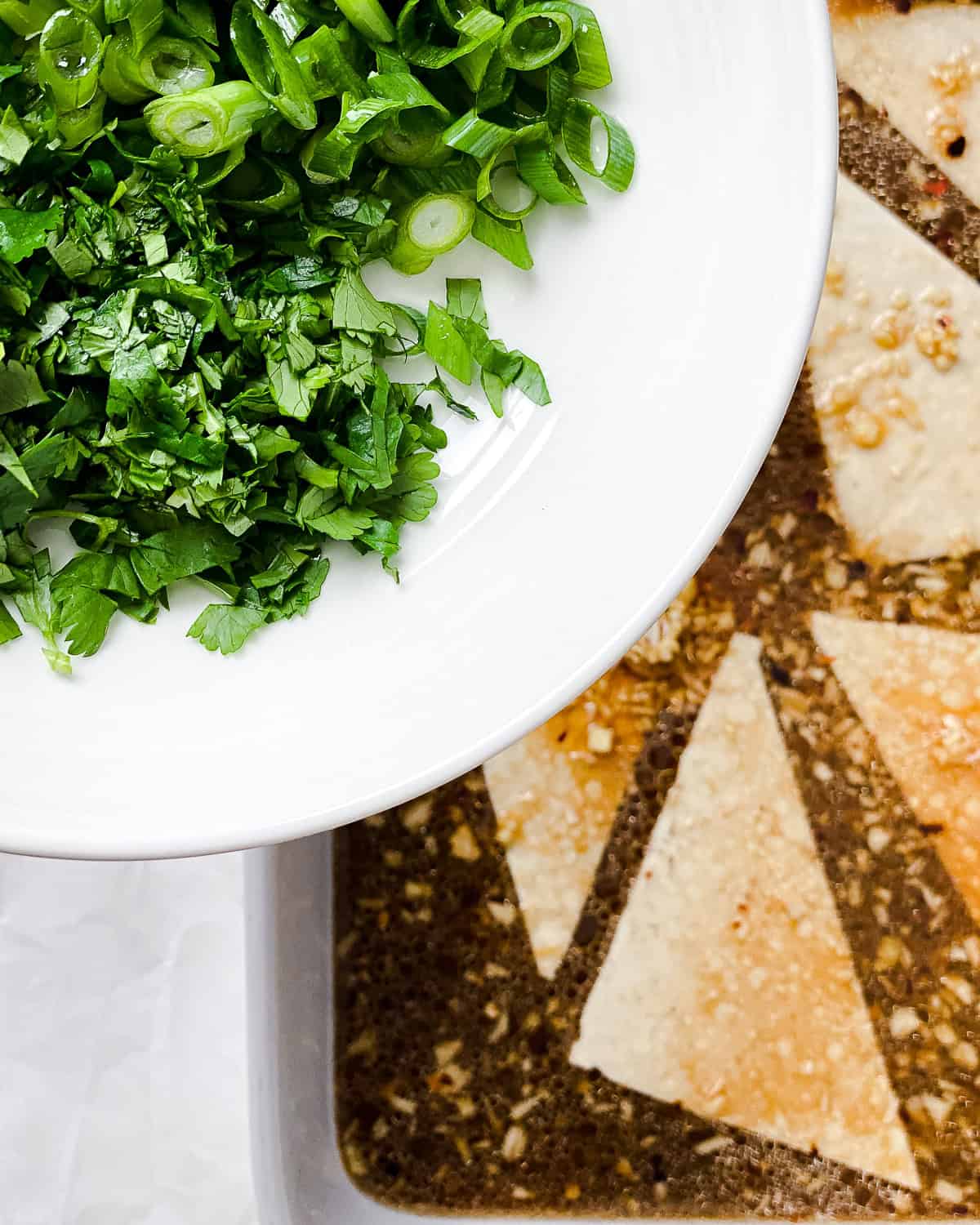 process shot showing adding cilantro and green onion on top of tofu