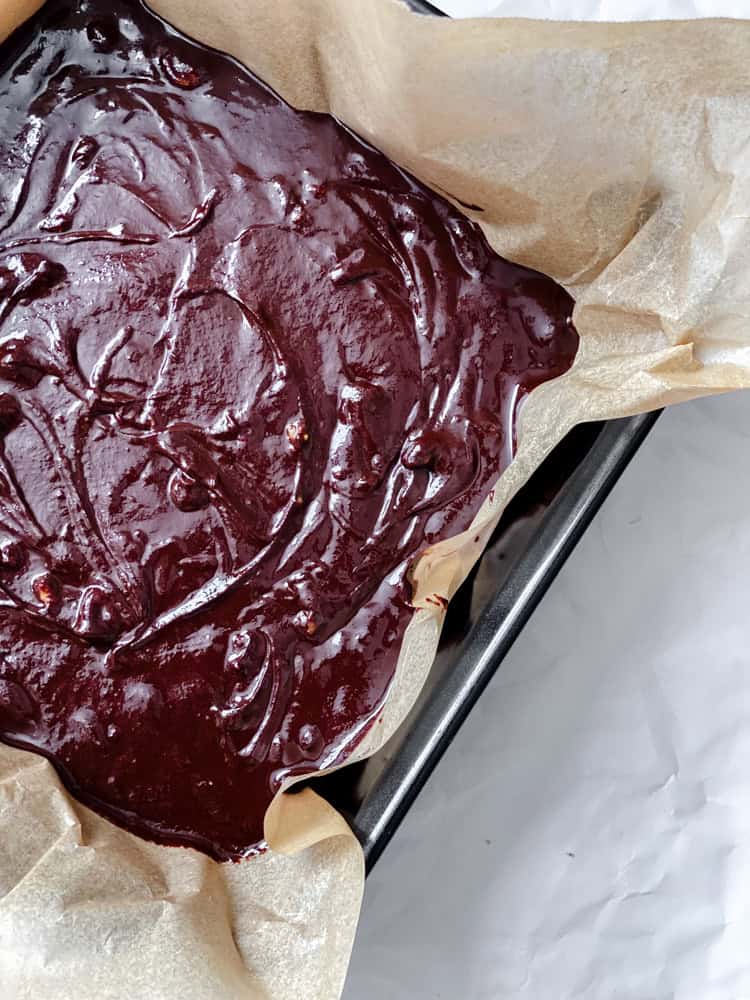 process shot showing chocolate fudge being added to baking dish