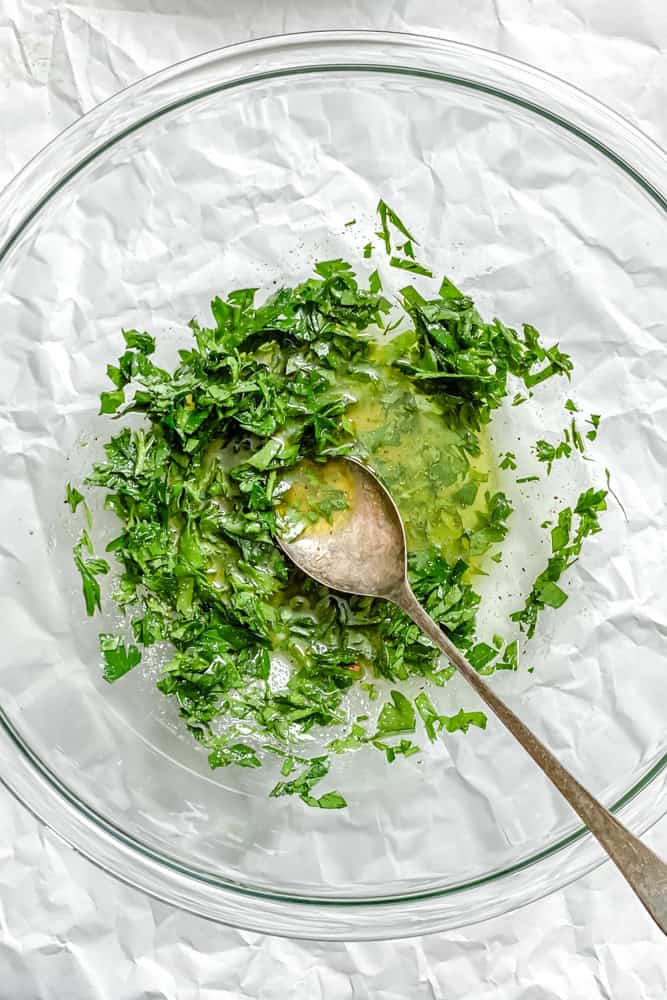 process shot showing mixing dressing ingredients together in a bowl