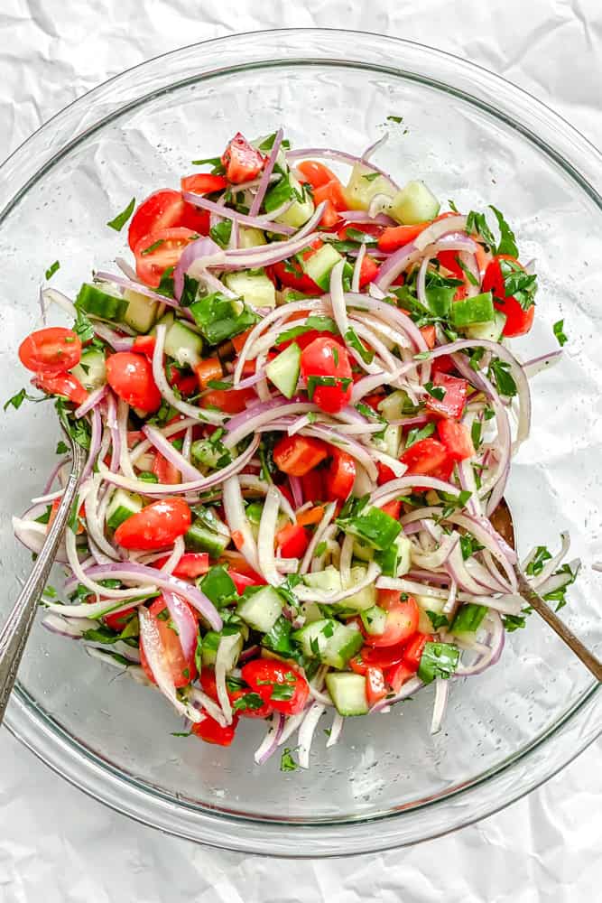 process shot showing mixing salad ingredients in a bowl