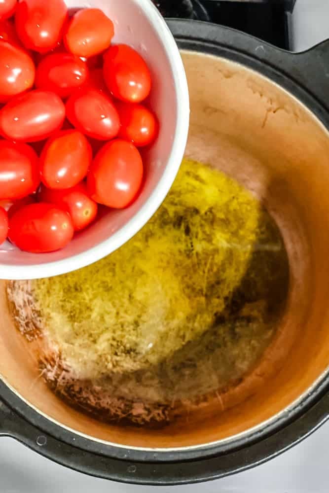 process shot of adding tomatoes to pot