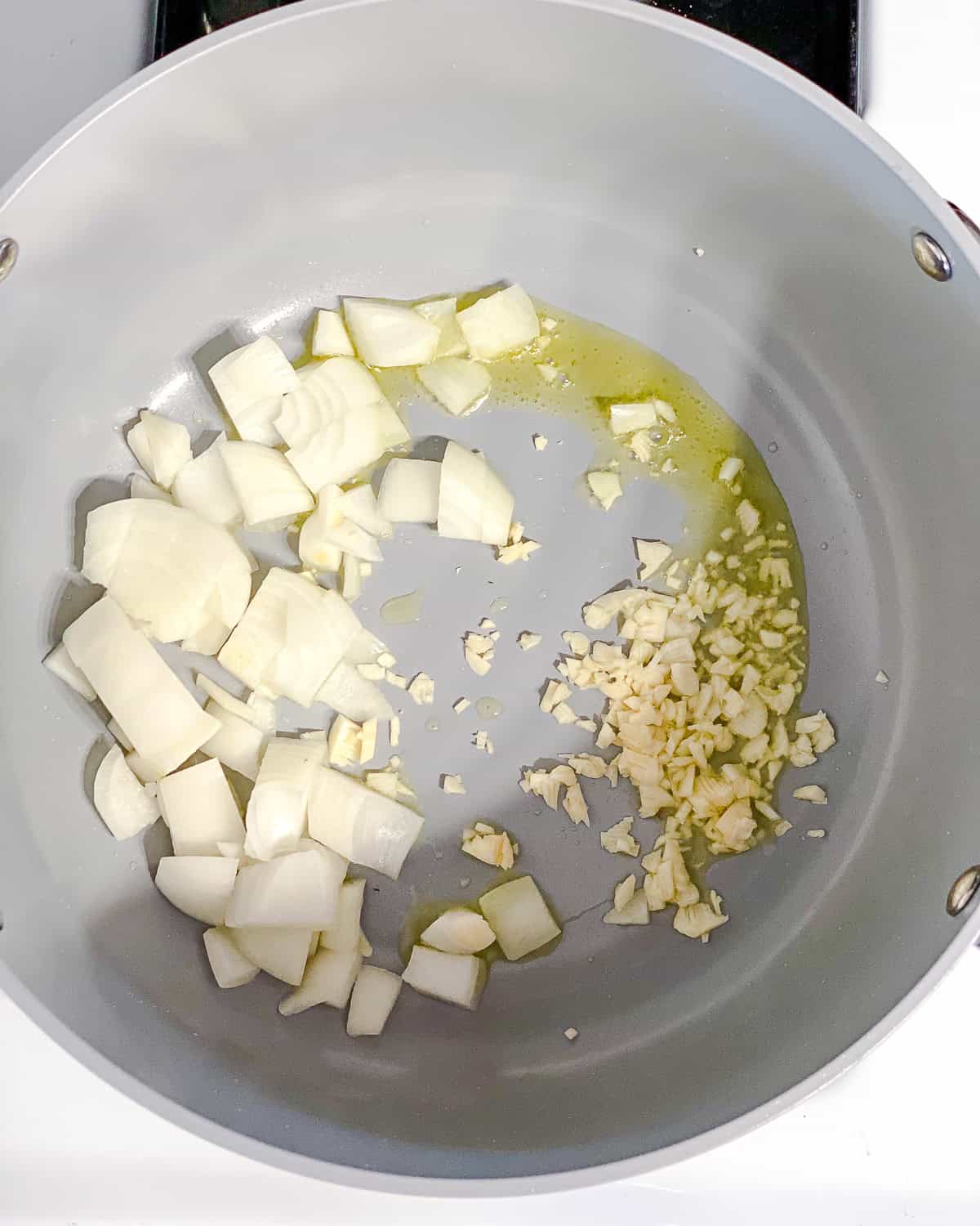 process shot showing onions and garlic cooking in pot