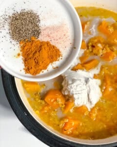 Process shot of adding spices to pot.