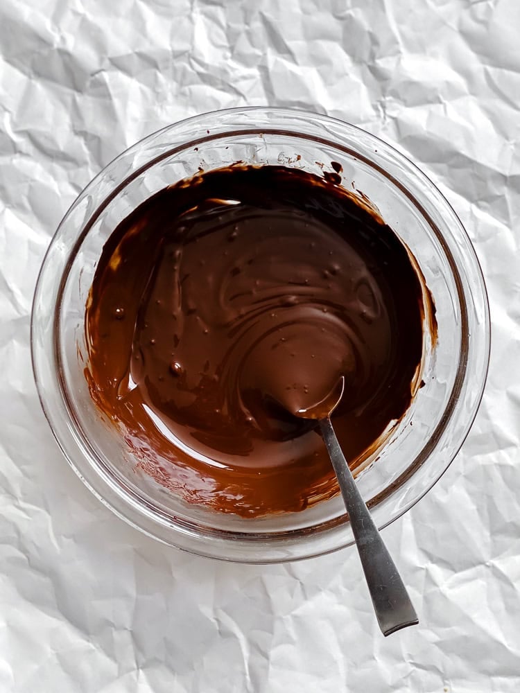 Process shot showing melted vegan chocolate in a bowl.