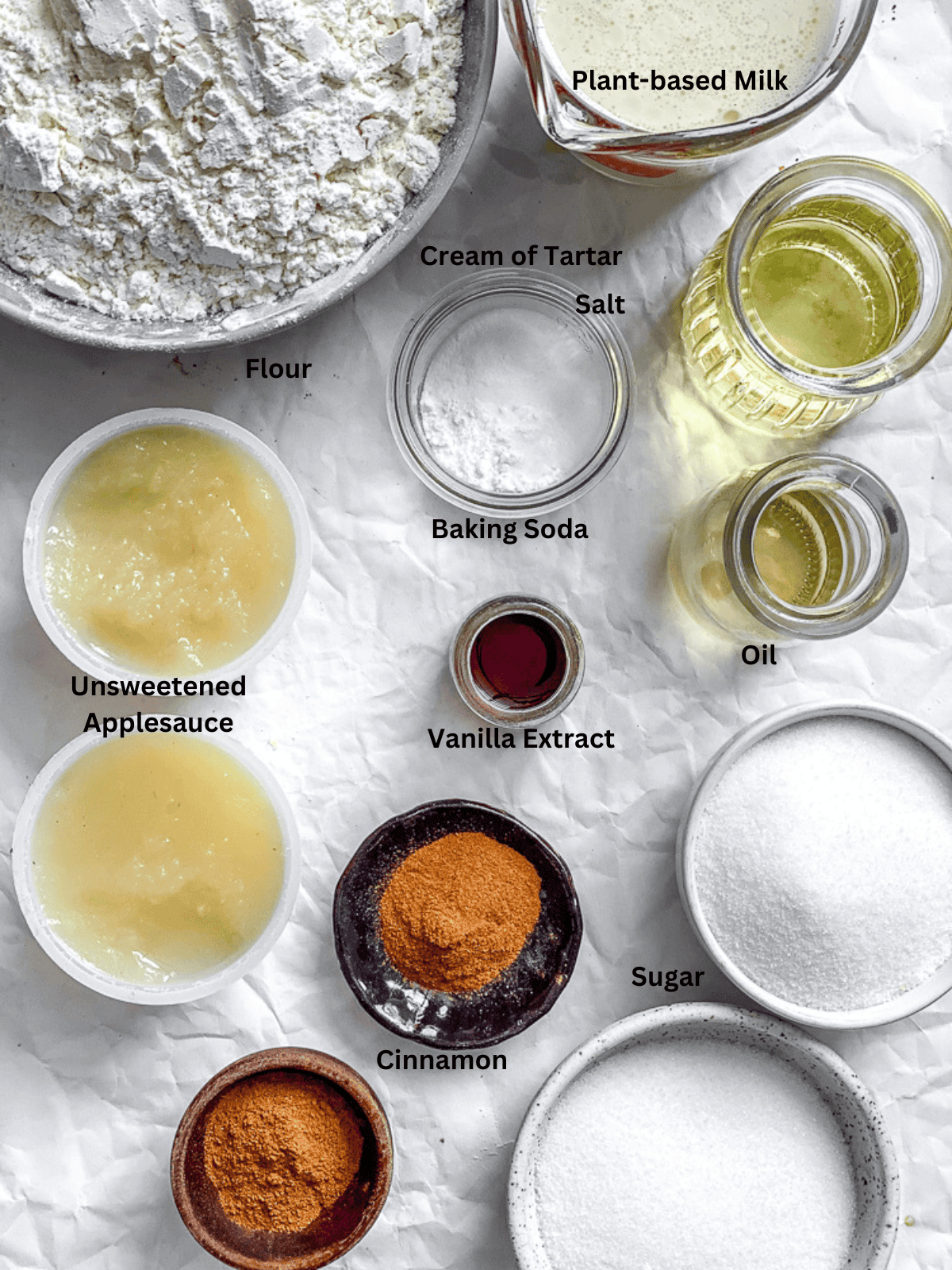Ingredients for Snickerdoodle Muffins (Egg-Free) measured out on a white surface.