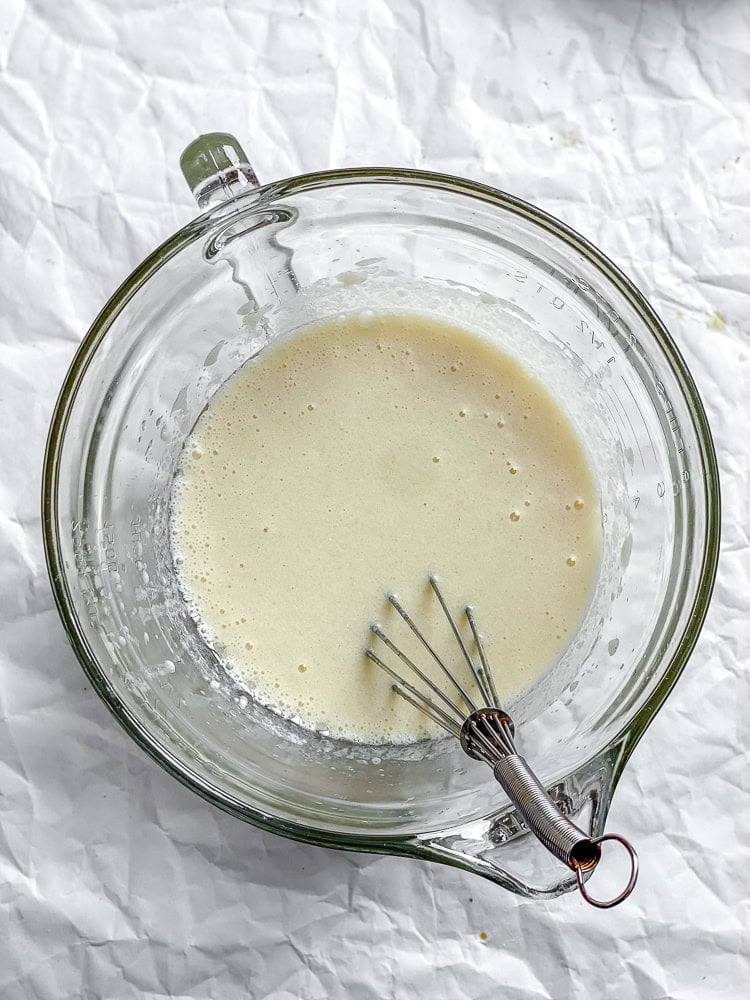Process shot showing whisking ingredients in a glass container.