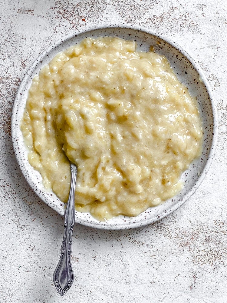 Process shot showing mashing banana in bowl.
