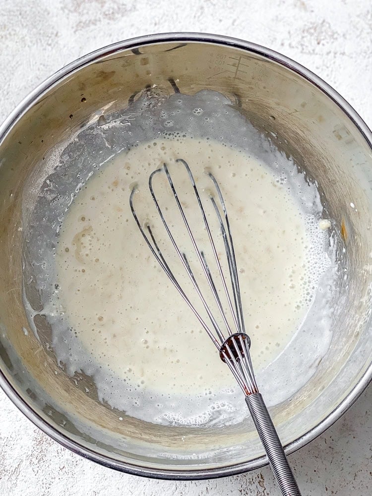 Process shot showing whisking ingredients together in bowl.