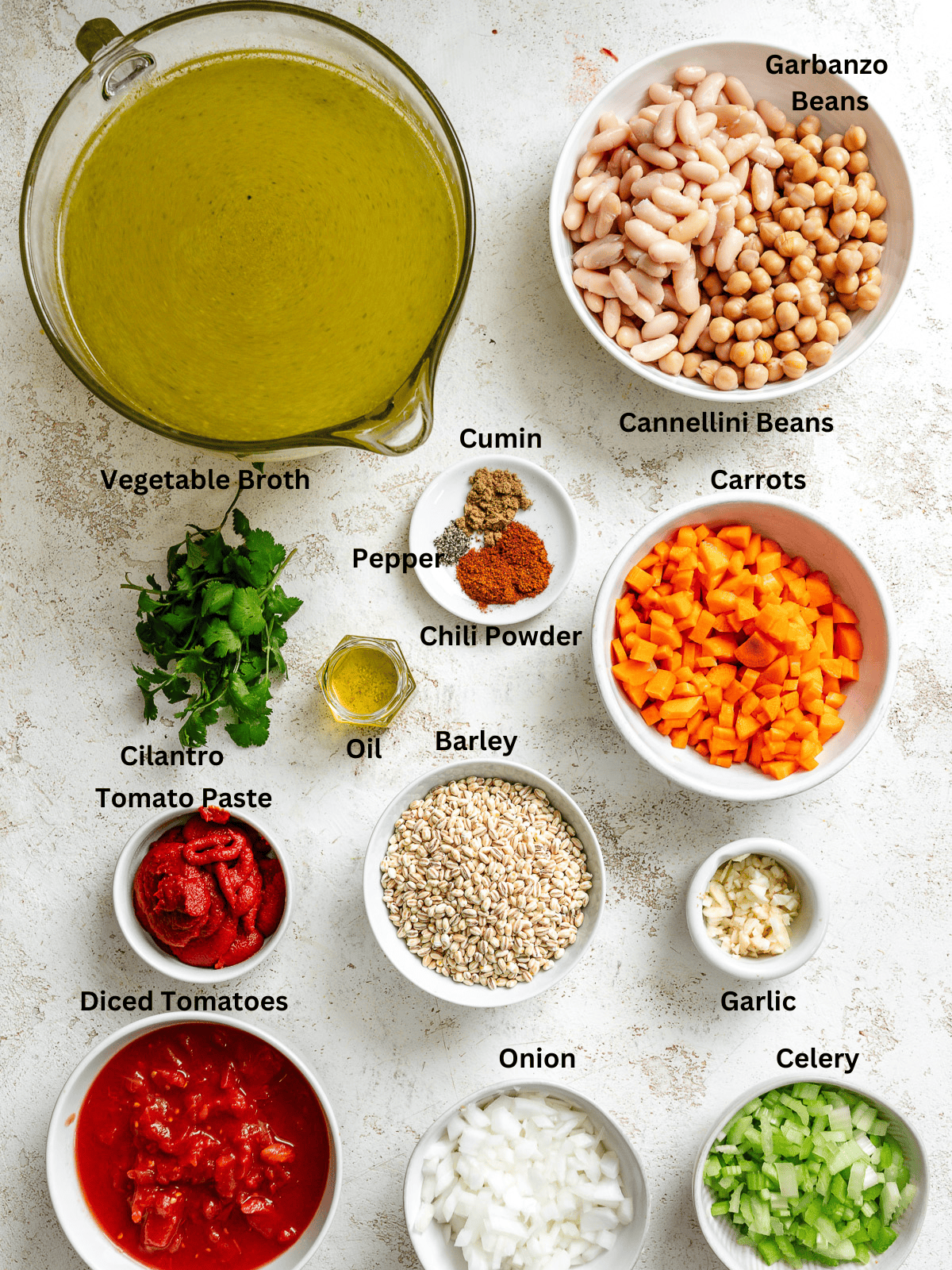 Ingredients for Barley and Bean Soup measured out on a white surface.