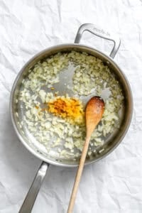Process shot showing stirring Bean Sprouts Curry in pot.
