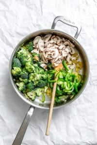 Process shot showing stirring Bean Sprouts Curry in pot.