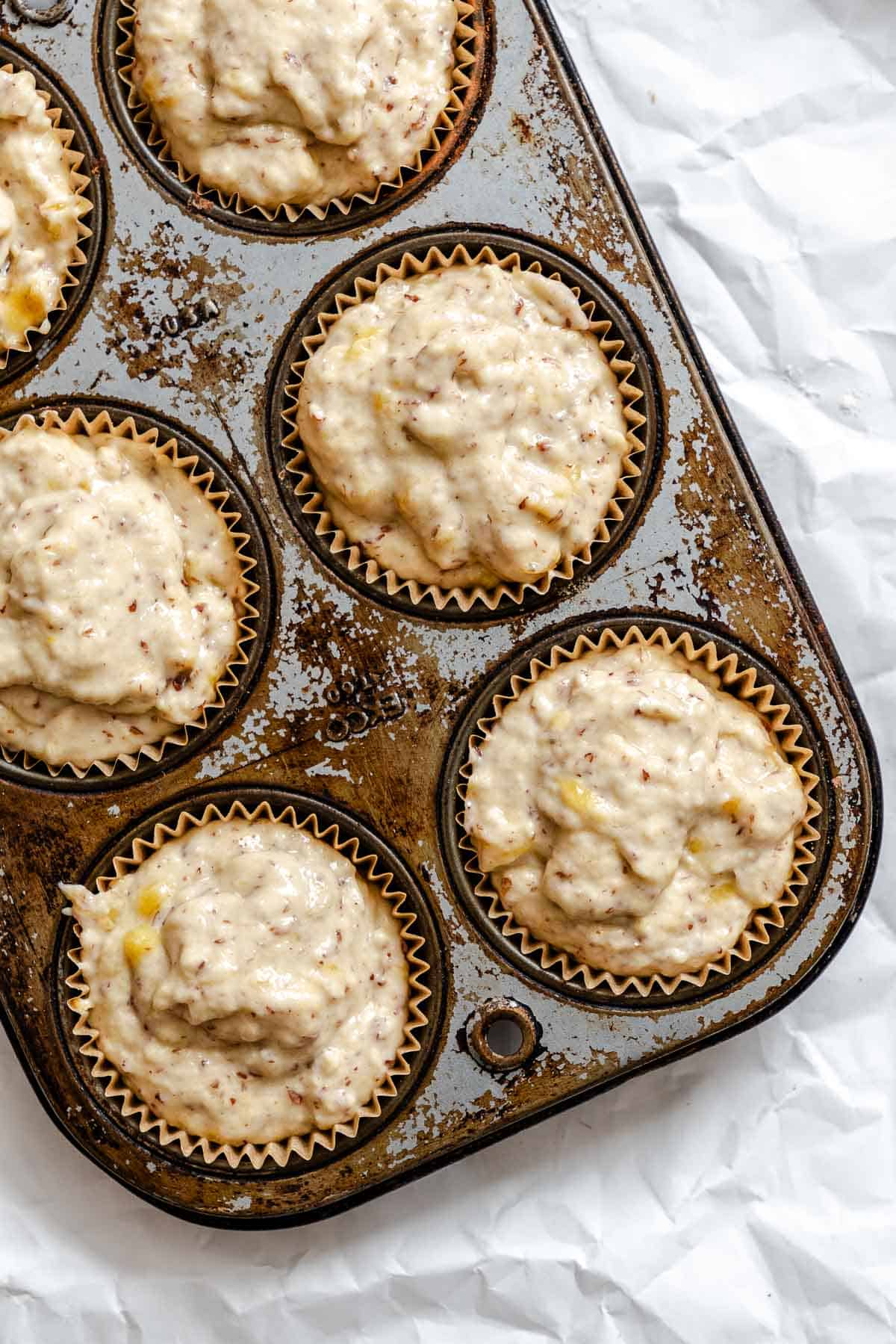 Process shot showing batter added to muffin tin.