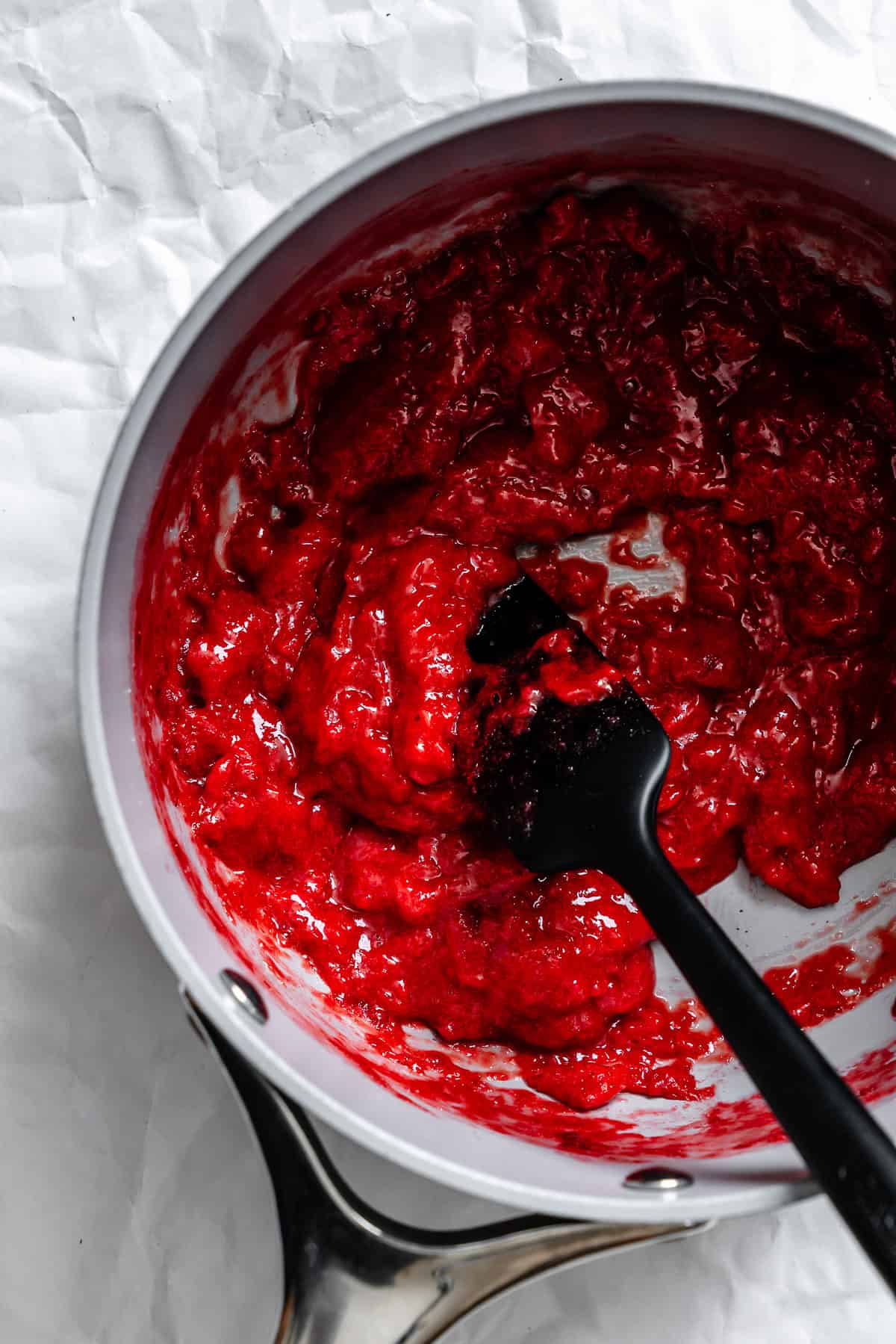 Process shot showing strawberries cooking in pan.