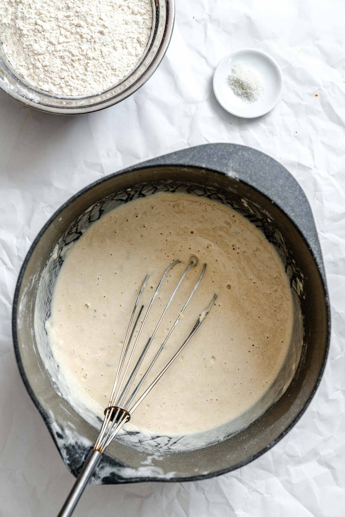 Process shot showing whisking ingredients in pan.