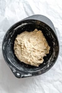 Process shot showing ball of dough in pan.