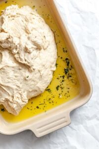 Process shot showing dough added to baking dish.