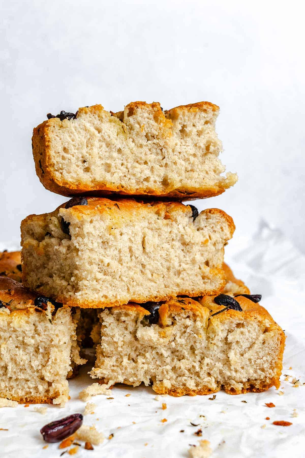 Completed Vegan Focaccia (Garlic and Herb) stacked on each other on a white surface.