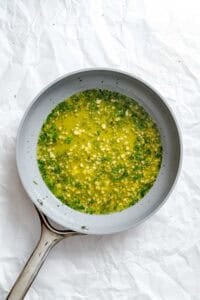 Process shot showing herb mixture in a bowl.