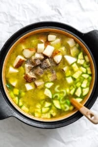 Process shot showing veggies added to pot.