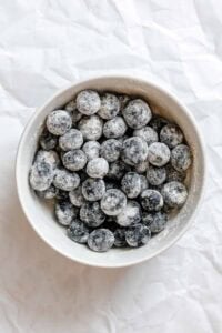 Process shot showing blueberries in a bowl.