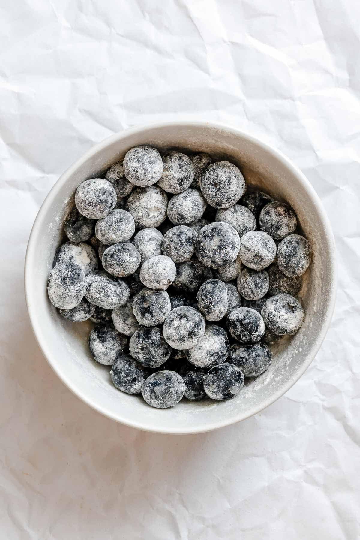 Process shot showing blueberries in a bowl.