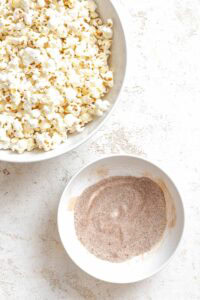 Process shot showing a bowl of popcorn alongside seasoning mix.