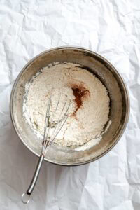 Process shot showing whisking ingredients in a bowl.