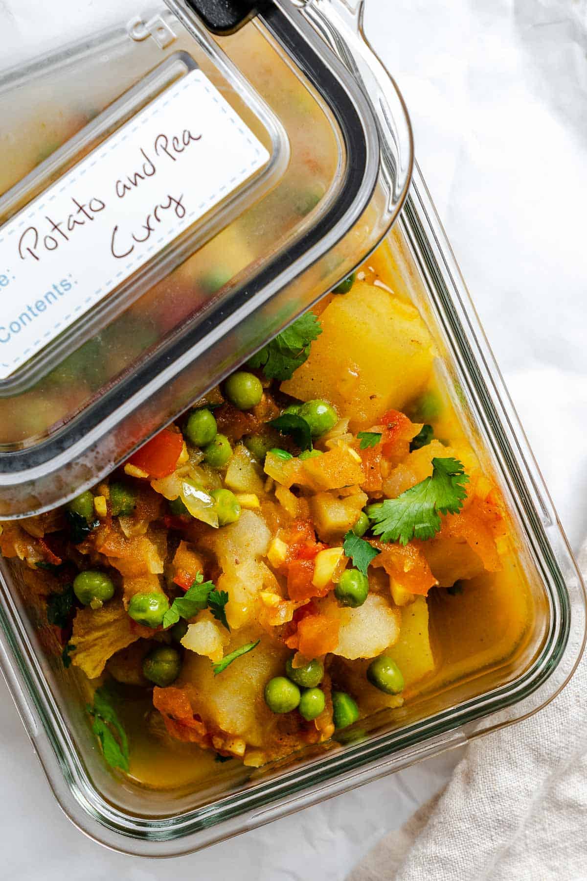 Completed Easy Potato and Pea Curry (Aloo Matar) in a storage container.