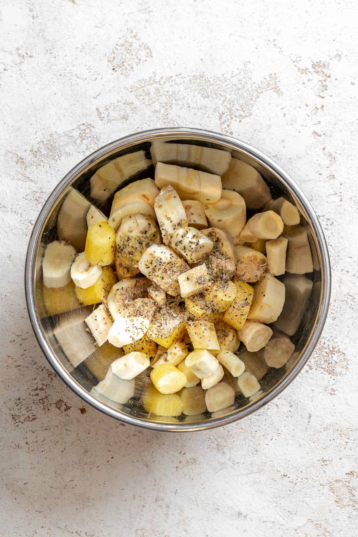 Process shot showing parsnips and ingredients in a bowl.