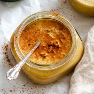 Completed Pumpkin Pie Overnight Oats in storage jar with spoon inside.