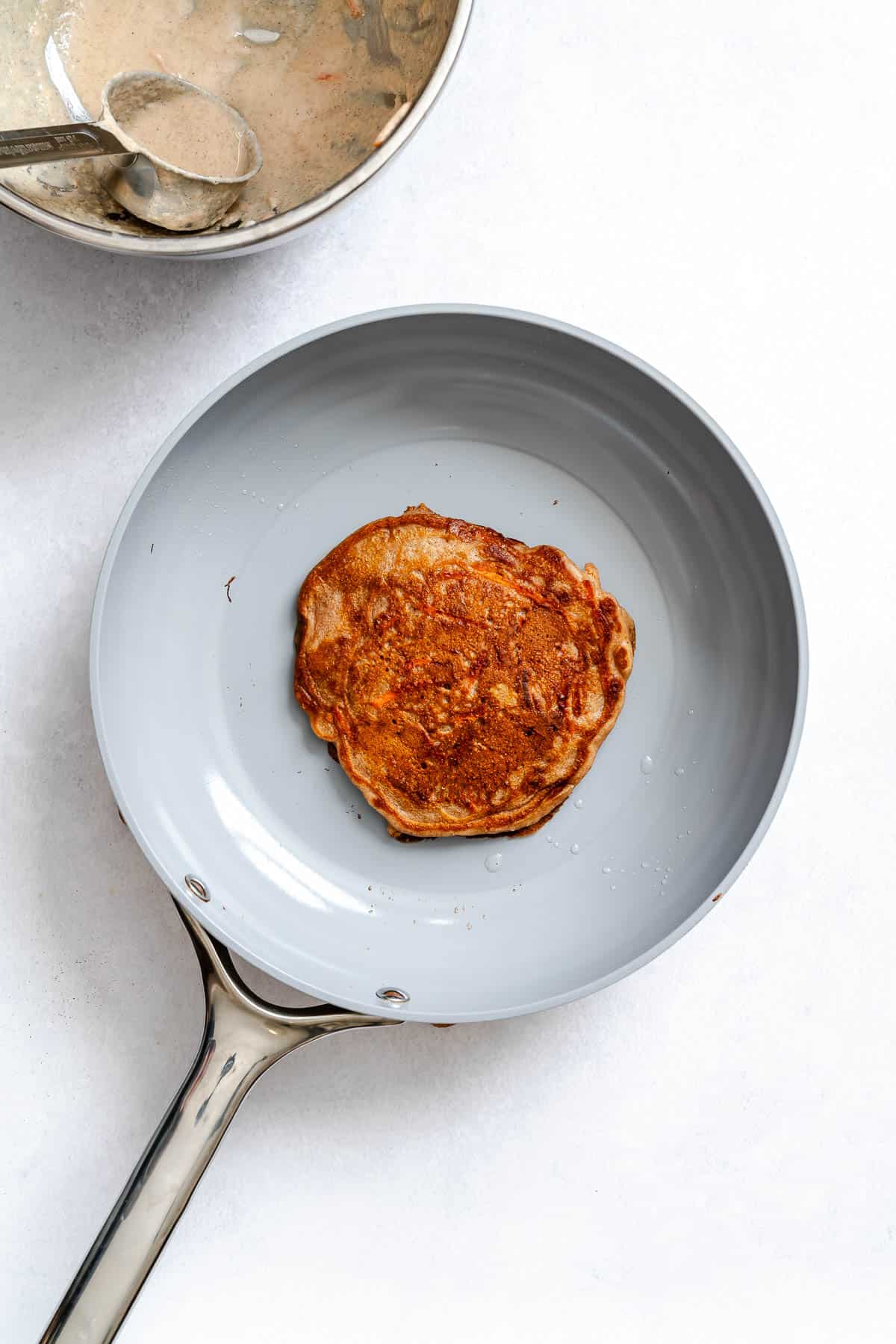 Process shot showing pancake cooking on pan.